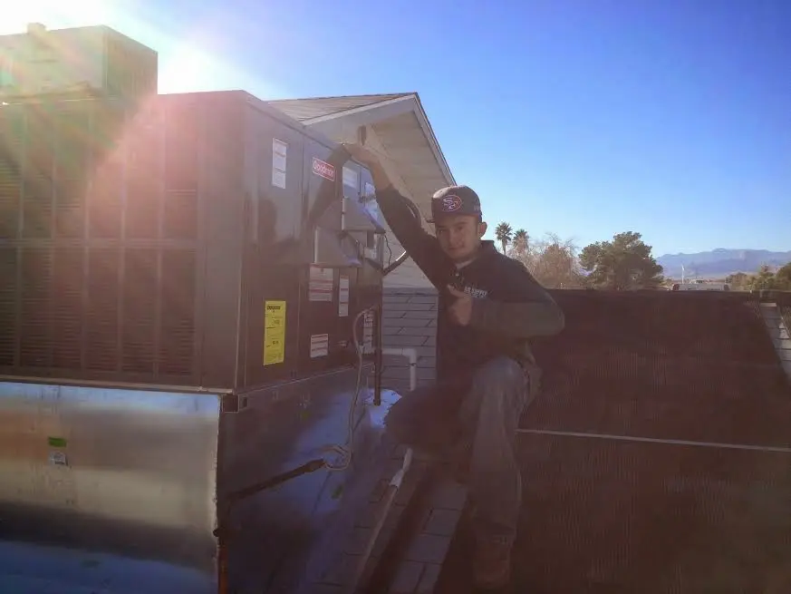 HVAC technician performing HVAC Inspection on a rooftop unit in Dudley